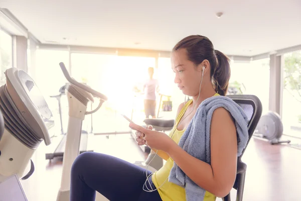 Женщин, использующих смартфон в фитнес-зале — стоковое фото