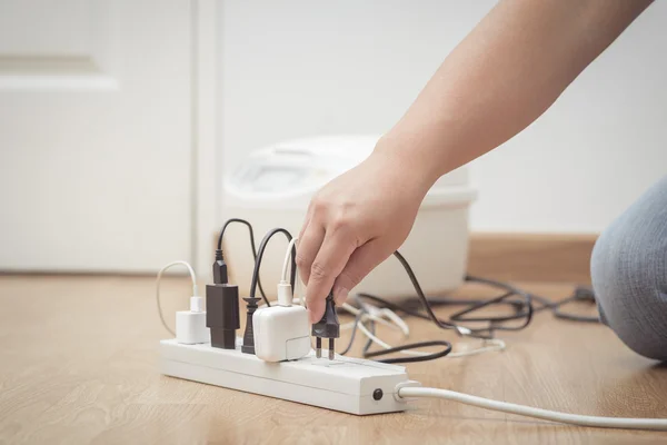 Man unplugged plug to save on energy — Stock Photo, Image