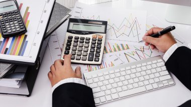 Ofis masaüstü bilgisayar ve belgelerine çalışan iş adamı