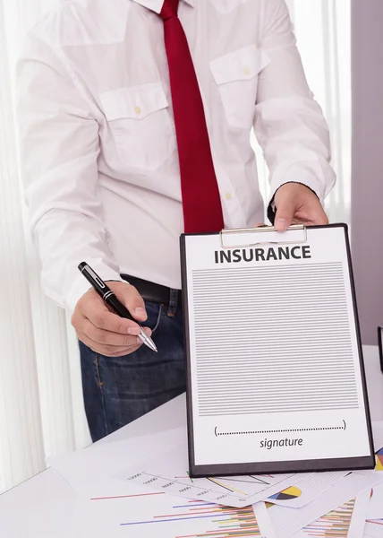 Junger Mann im Anzug in seinem Büro mit einer Versicherung und — Stockfoto