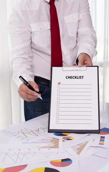 Affärsman holding Urklipp med checklista mot — Stockfoto