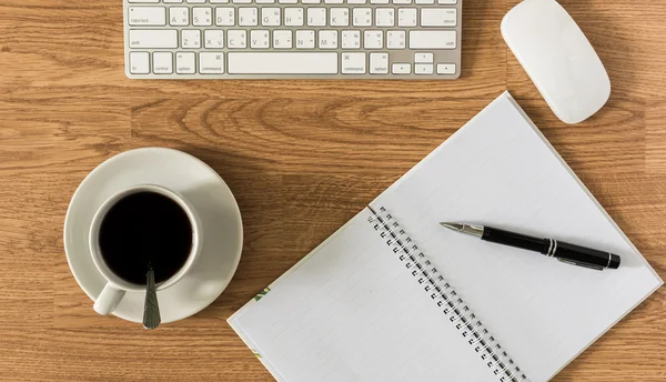 Mesa de escritório com notepad, computador e xícara de café e computador — Fotografia de Stock