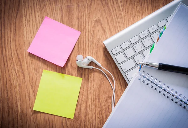 Not defteri, bilgisayar klavyesi, kahve fincanı, kalemile ofis masası ,