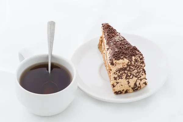 Rebanada de pastel de chocolate con rizo en plato blanco con bebida caliente —  Fotos de Stock