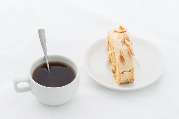 Pastel de rollo de almendras en plato blanco con bebida caliente — Foto de Stock