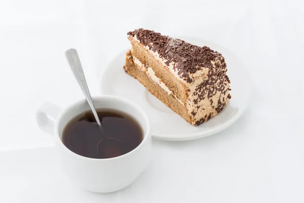 Fatia de bolo de chocolate com curl no prato branco com bebida quente — Fotografia de Stock