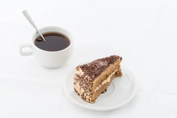 Rebanada de pastel de chocolate con rizo en plato blanco con bebida caliente —  Fotos de Stock