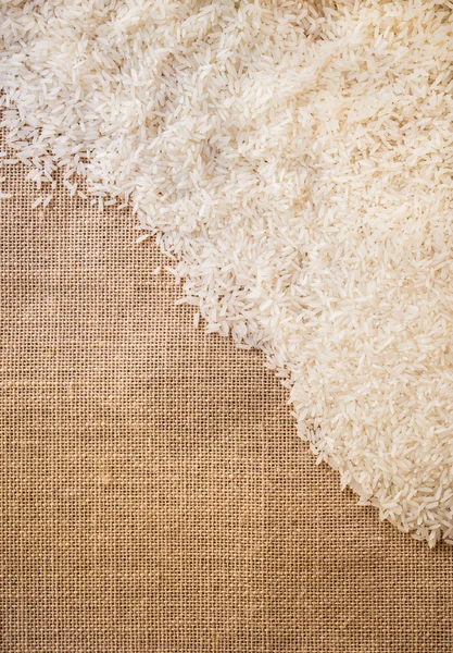 Arroz sobre pano de saco uso para fundo — Fotografia de Stock