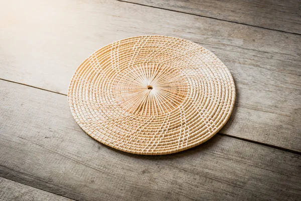 Rieten placemat op houten tafel — Stockfoto