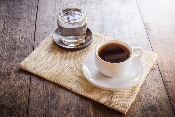 Una taza de café sobre una mesa de madera —  Fotos de Stock