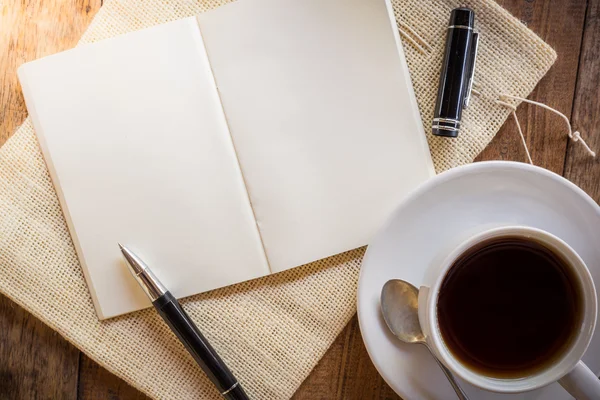 Cuaderno en blanco con pluma y taza de café —  Fotos de Stock