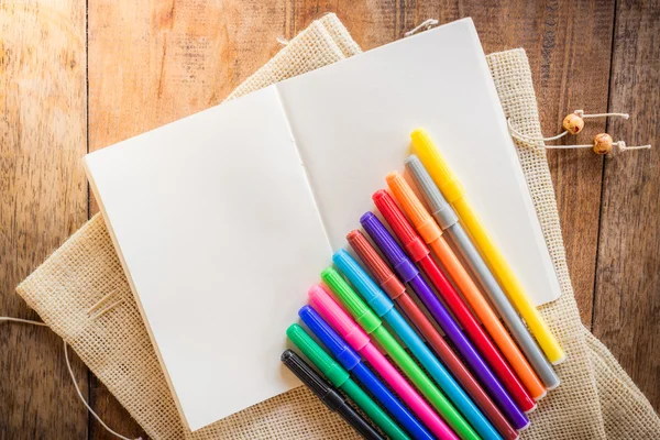 Caderno em branco com muitos marcadores de cor — Fotografia de Stock