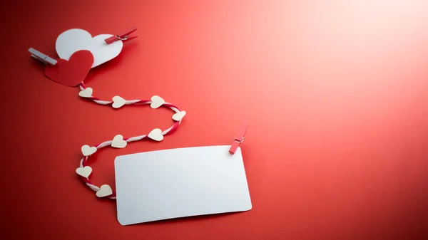 Valentine's paper hearts with a blank business card and Clothesp — Stock Photo, Image