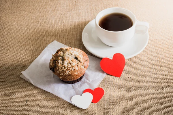 Chocolade muffin en koffie en harten op zak texturen — Stockfoto