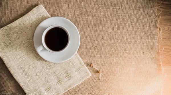 Taza de café en texturas de tela de saco — Foto de Stock