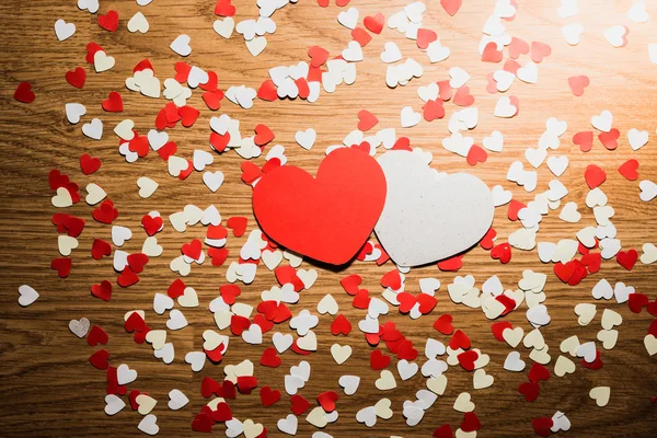 Muitos coração vermelho e branco em um fundo de madeira — Fotografia de Stock