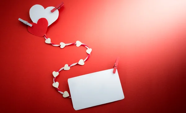 Valentine's paper hearts with a blank business card and Clothesp — Stock Photo, Image