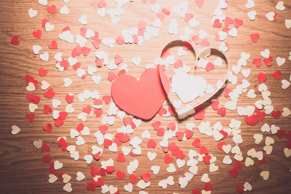 Många röda och vita hjärtat på en trä bakgrund — Stockfoto