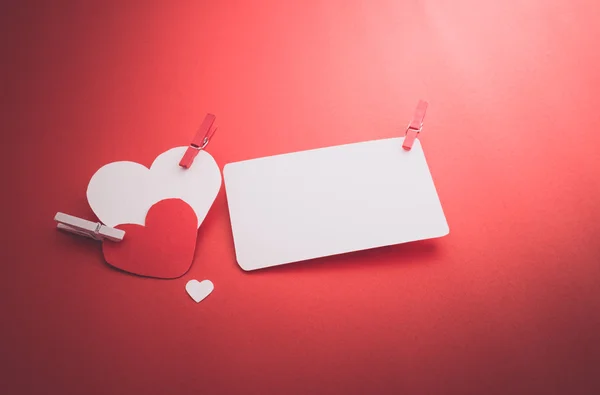 Valentine's paper hearts with a blank business card and Clothesp — Stock Photo, Image