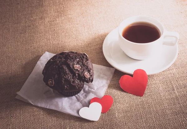 Schokoladenmuffin und Kaffee und Herzen auf Sacktuch-Texturen — Stockfoto