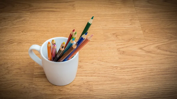 Lápices de color en taza de café blanco —  Fotos de Stock