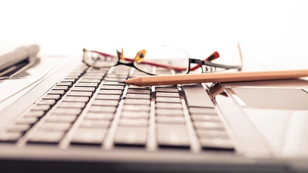 Modern business desk with laptop, pencil and glasses — Stock Photo, Image