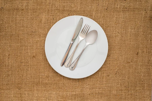 Пустая белая тарелка и ложка, вилка, нож — стоковое фото