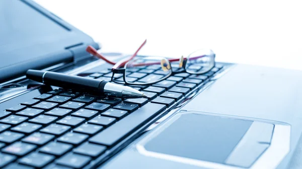 Modern business desk with laptop, pen and glasses — Stock Photo, Image