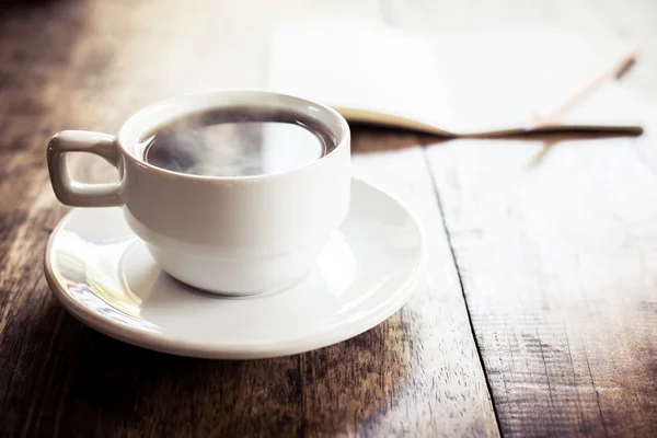 Una taza de café sobre una mesa de madera —  Fotos de Stock