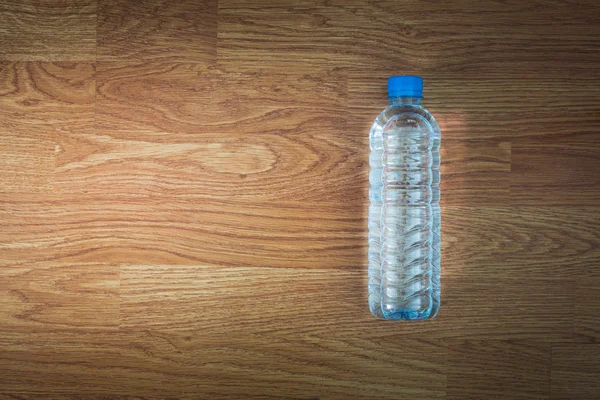 Bouteille d'eau plastique sur la table en bois — Photo