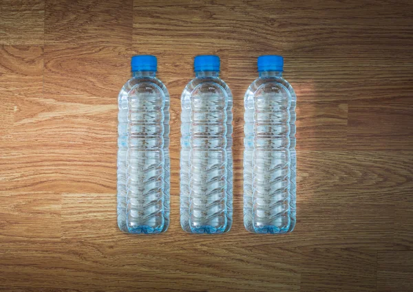 Plastová láhev s vodou na dřevěném stole — Stock fotografie