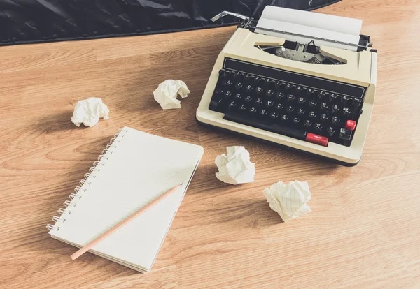 Винтажная пишущая машинка и чистый блокнот бумаги — стоковое фото
