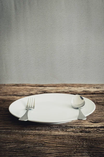 Beyaz plaka ve gümüş çatal, bıçak. ahşap masa — Stok fotoğraf