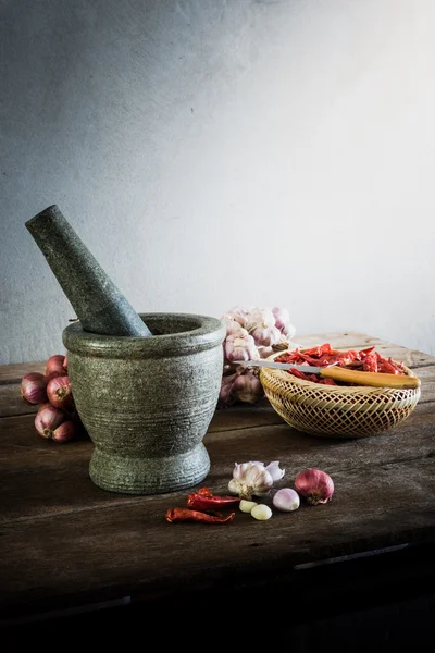 Dry chili pepper and red onion and garlic and stone mortar on an — Stock Photo, Image