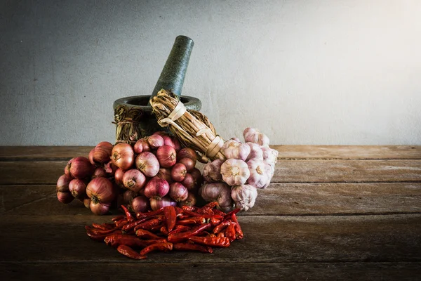 Chili peper en rode ui en knoflook en steen mortel drogen op een — Stockfoto