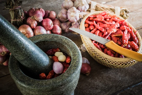 Chili peper en rode ui en knoflook en steen mortel drogen op een — Stockfoto