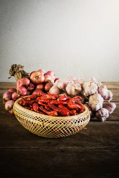 Cebulę, czosnek i suchą chili na drewnianym stole — Zdjęcie stockowe