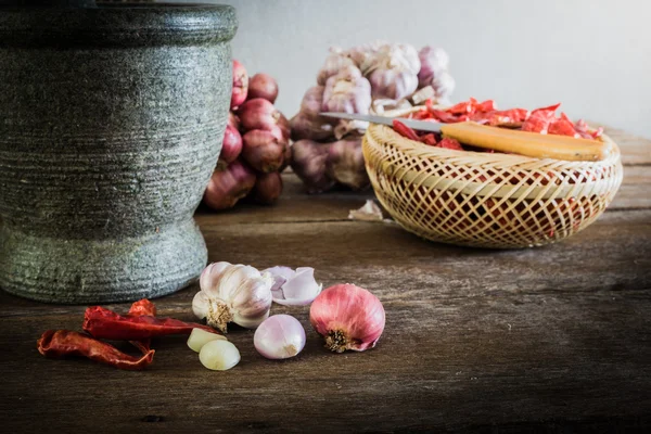Suché chilli a červené cibule a česnek a kamenné malty na — Stock fotografie