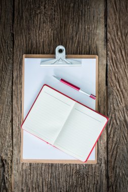 Eski ahşap yüzey üzerinde eski Pano, kırmızı defter, kırmızı kalem