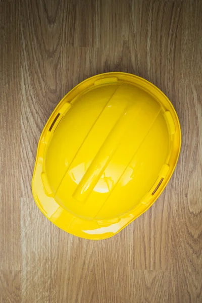 木制的背景上黄色工业防护头盔 — 图库照片
