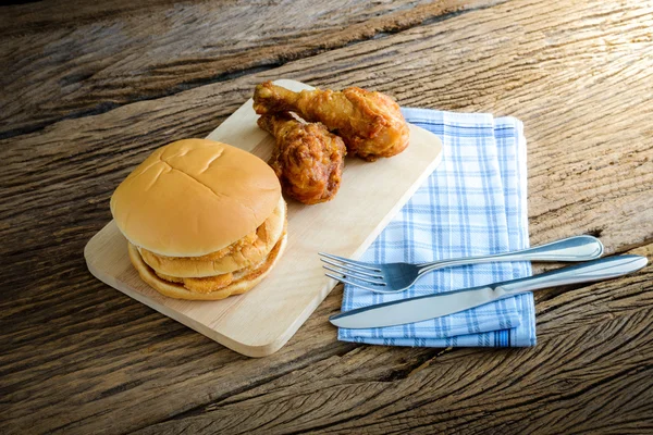 Kip hamburger en gebakken kip op houten snijplank met — Stockfoto