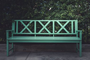 Yeşil Ahşap Bank ve yeşil yaprakları duvar