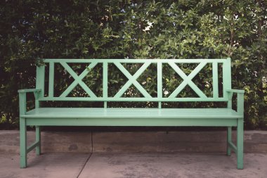 Yeşil Ahşap Bank ve yeşil yaprakları duvar