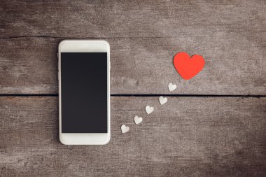 Smartphone ve hearts Kağıt ahşap arka plan üzerinde