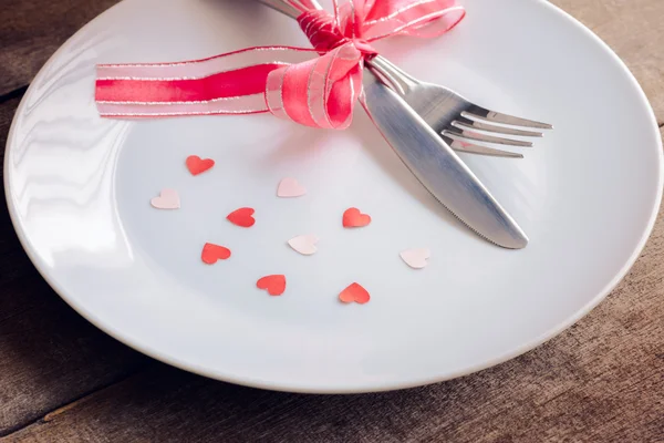 De dag van Valentijnskaarten tabel instelling met mes, vork, plaat, rood lint — Stockfoto