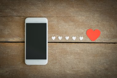 Smartphone ve hearts Kağıt ahşap arka plan üzerinde
