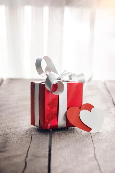 Kotak hadiah merah dan jantung di atas meja kayu putih — Stok Foto