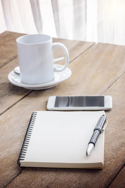 Xícara de café, notebook, caneta e telefone inteligente — Fotografia de Stock