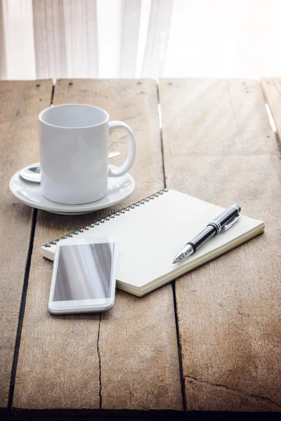 Xícara de café, notebook, caneta e telefone inteligente — Fotografia de Stock