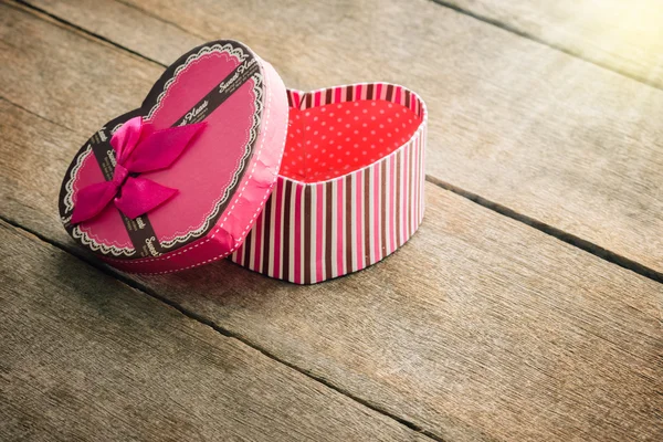 Caja de regalo de San Valentín en forma de corazón en placa de madera antigua vintage — Foto de Stock